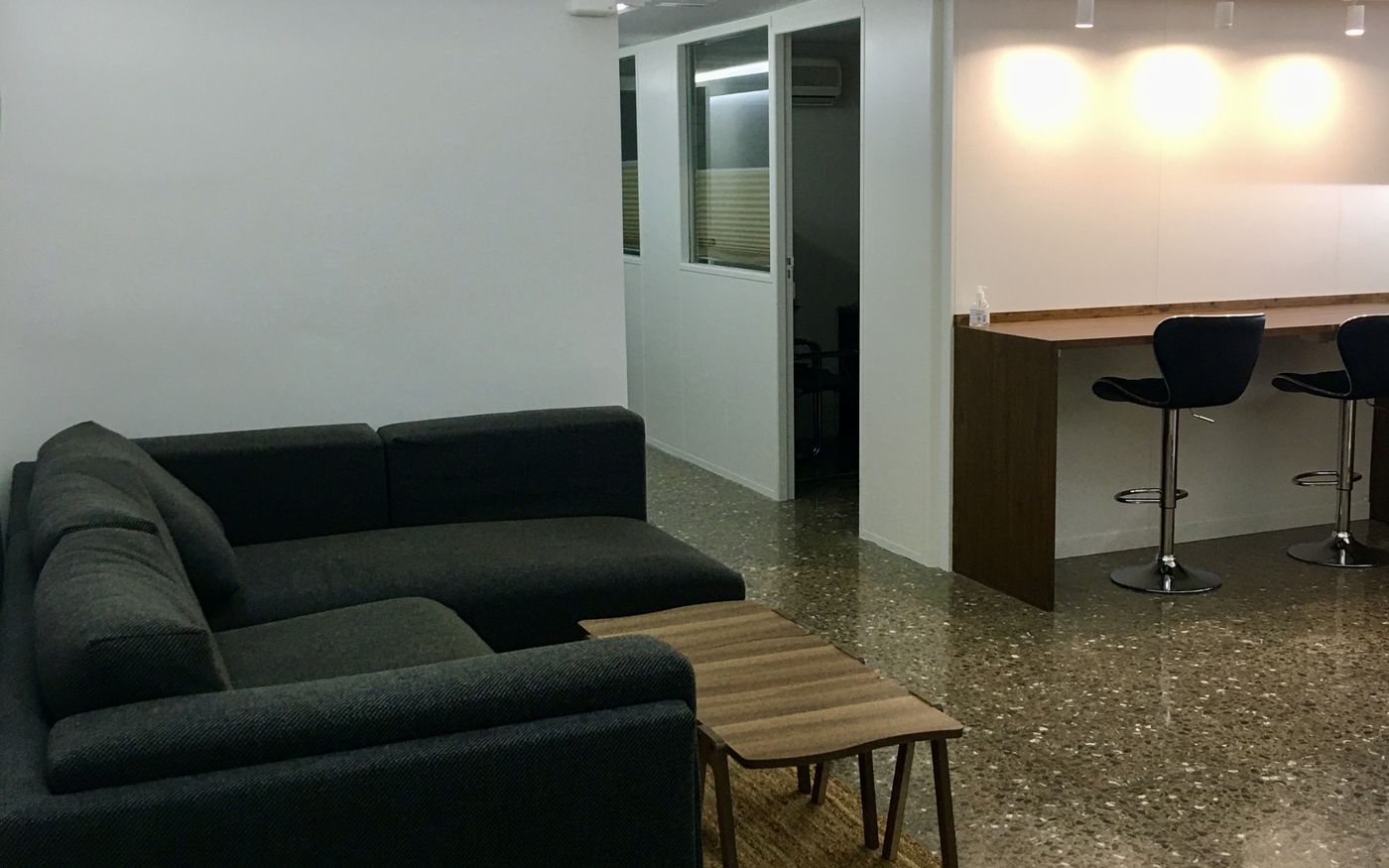 Zona común de WorkSpace.Cat con sofá, mesa alta y cafetera